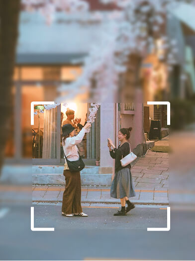外で携帯を使いながら楽しく遊んでいる女性たちの様子